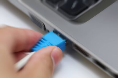 motion blur background of hand connecting lan port to laptop computer