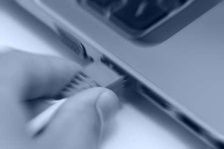 motion blur background of hand connecting lan port to laptop computerの写真素材