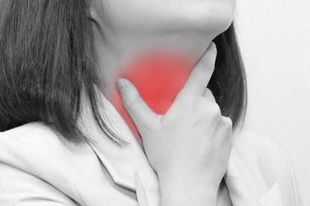woman touch her throat because of sore throatの写真素材