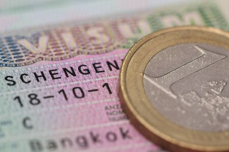 close up schengen visa in the passport with euro coinの写真素材