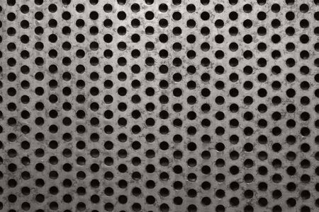 background of rusty metal with seamless perforated holesの写真素材