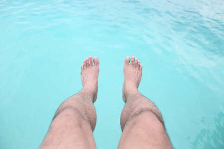 male's feet against a beautiful blue seaの写真素材