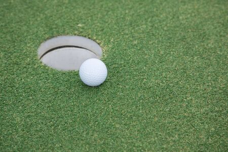 background of golf ball on lip of cup