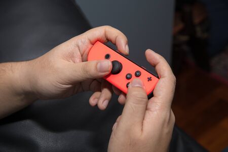 BANGKOK, THAILAND- MAY 20:  Hand holding a Nintendo Switch game controller on May 20,2017.