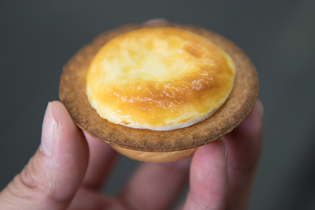 background of hokkaido cheese tart in a handの写真素材