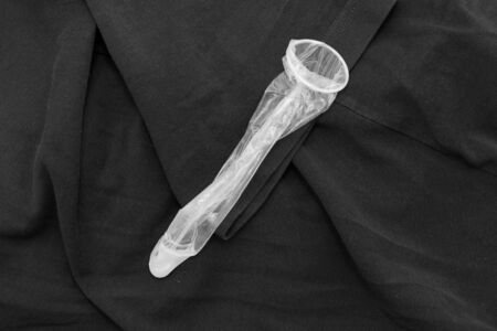 Used condom on black clothの写真素材