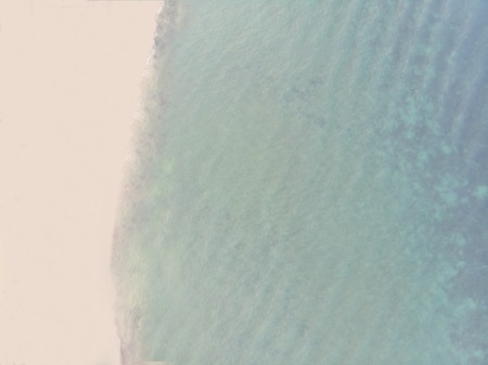 Aerial View of Sandy Beach and Blue Sea