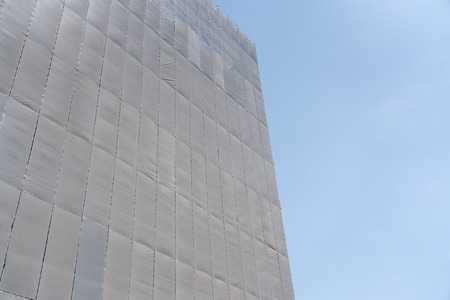 Construction site with the safety building net cover the building  against sky background