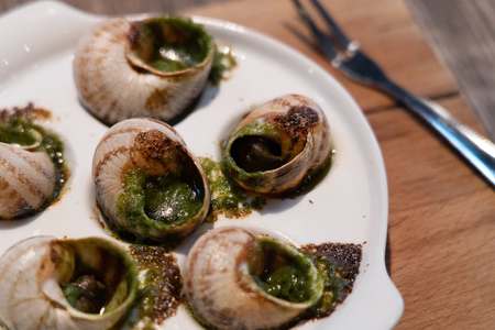 Escargots de Bourgogne or  Snails with garlic herbs butter on the wooden tableの写真素材
