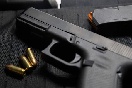 Handgun with bullets on bullet proof vest texture background