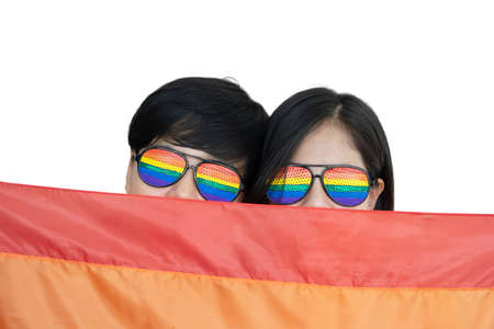 Close-Up on Lesbian Couple Face with Rainbow Glasses under LGBTQ Flag on White Background