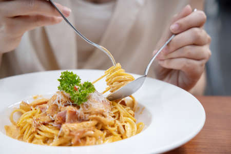 Close-up on Woman Eating Cabonara Spaghetti with a Forkの写真素材