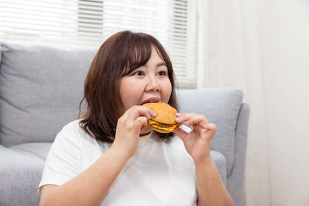 Overweight Woman Enjoy Eatting Beef Cheese Burgerの写真素材