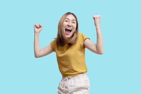 Isolated Asian Woman Raised Her Hand Celebrating Successの写真素材