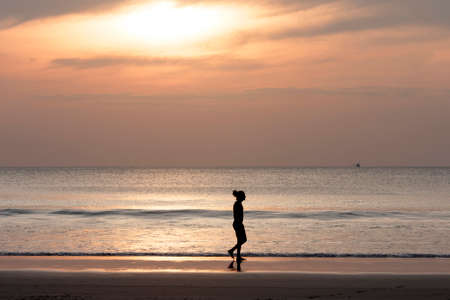 Man walking on the beach at sunset for holiday time, Silhouette sunsetのeditorial素材