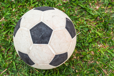 Old soccer ball on a football field の写真素材
