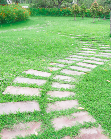 Walking trails, beautiful gardens, paved with stone slabs on the grass green.の写真素材