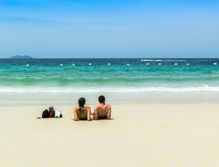 Relaxing on the beach, a couple of men and women during the holidays. Or take a break from workの写真素材