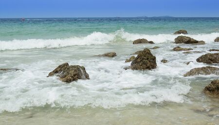 The erosion of the waves that crash along the banks of the rocky beach.の写真素材