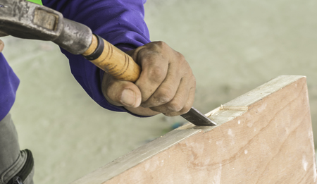 Carpenter using a chisel, drill to install a hinged wooden doors to stretch the door.の写真素材