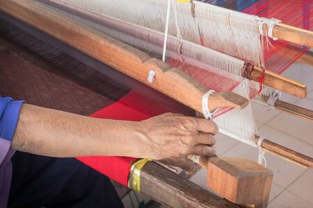 Old woman in Thailand are hand weaving. The arms were seized in the weaving machine.の写真素材