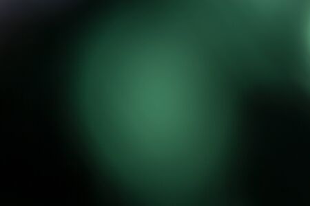 Green background, taken through a green filter in the light toward the sun, adjusting the image to be blurred a white light in the center.の写真素材