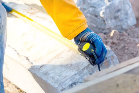 Technicians are using the meter to check the length of the poles. During the light impact on the concrete pole.の写真素材