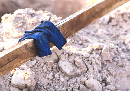 Old blue cloth gloves placed on wooden rails.の写真素材