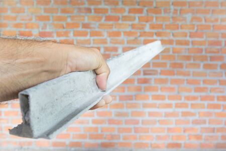 The concrete lumberer handles the plaster line pointing to the brick wall to begin plastering the concrete.の写真素材