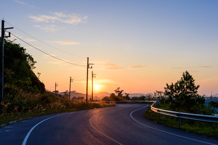 Road around the dam in the morning with the san on background.