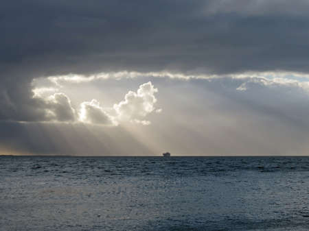 Sun behind the clouds at sea        の写真素材
