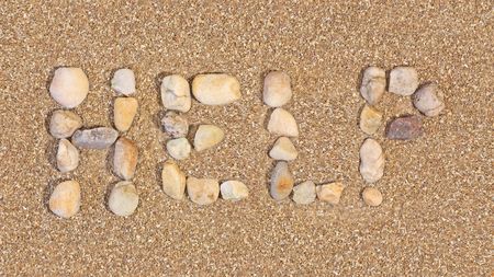 Help written in the sand using rocksの写真素材