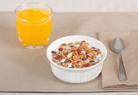 Breakfast cereal with fruit and nuts and orange juice