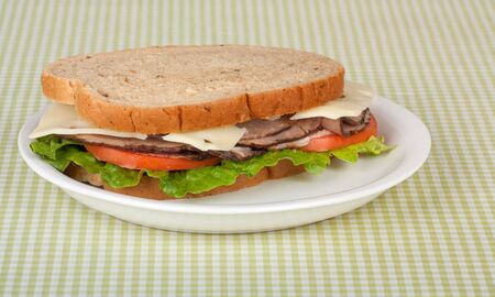 Roast beef sandwich on rye bread with swiss cheese, tomato, and lettuceの写真素材
