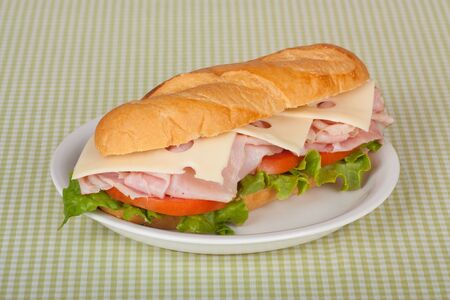 Ham and swiss cheese sub sandwich with lettuce and tomato on a bunの写真素材