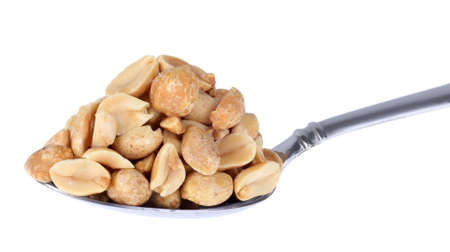 Heaping pile of peanuts on a spoon isolated on whiteの写真素材