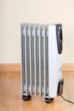 Electric radiator room space heater on a wood floorの写真素材