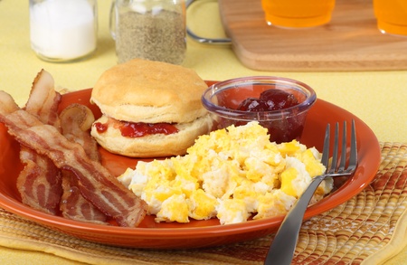 Bacon and scrambled egg breakfast with a biscuitの写真素材