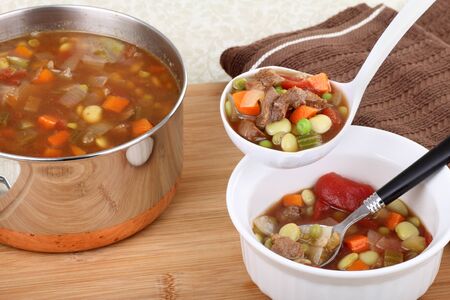 Serving vegetable beef soup in a ladleの写真素材