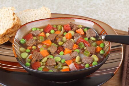 Vegetable beef soup in a brown bowlの写真素材