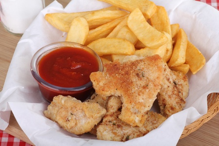 Breaded fish with french fries and sauce in a basketの写真素材