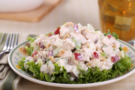 Chicken salad with apple pieces and nuts on top of lettuceの写真素材