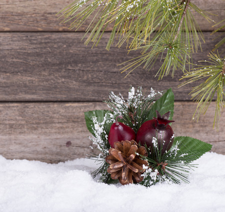 Christmas ornament on snow on a wooden backgroundの写真素材