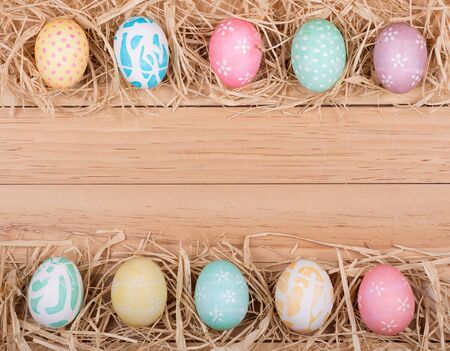 Decorated Easter eggs forming a border on a wood backgroundの写真素材