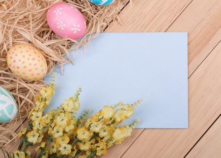 Blank envelope bordered with decorated Easter eggs and flowersの写真素材
