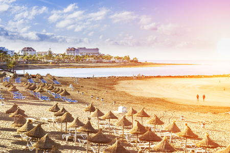 TENERIFE, SPAIN - JANUARY 14, 2013: Straw umbrellas and loungers on the Playa de Las Americas, Tenerife, Canary Islands, Spainのeditorial素材