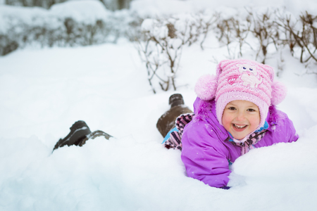 Cheerful little girl playing with snow in winter snowy Park, Krasnoe Selo, Saint-Petersburg, Russiaの写真素材