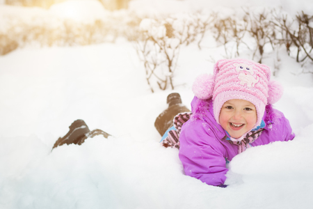 Cheerful little girl playing with snow in winter snowy Park, Krasnoe Selo, Saint-Petersburg, Russiaの写真素材