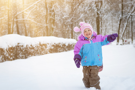 Cheerful little girl playing with snow in winter snowy Park, Krasnoe Selo, Saint-Petersburg, Russiaの写真素材