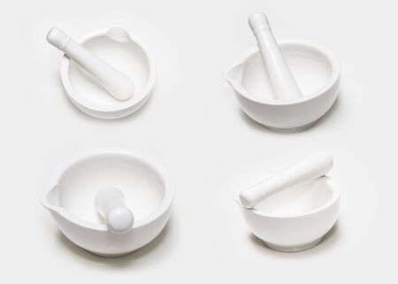 Set of four white ceramic mortar and pestle isolated on white background